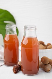 Tamarind juice and fresh fruits on white table