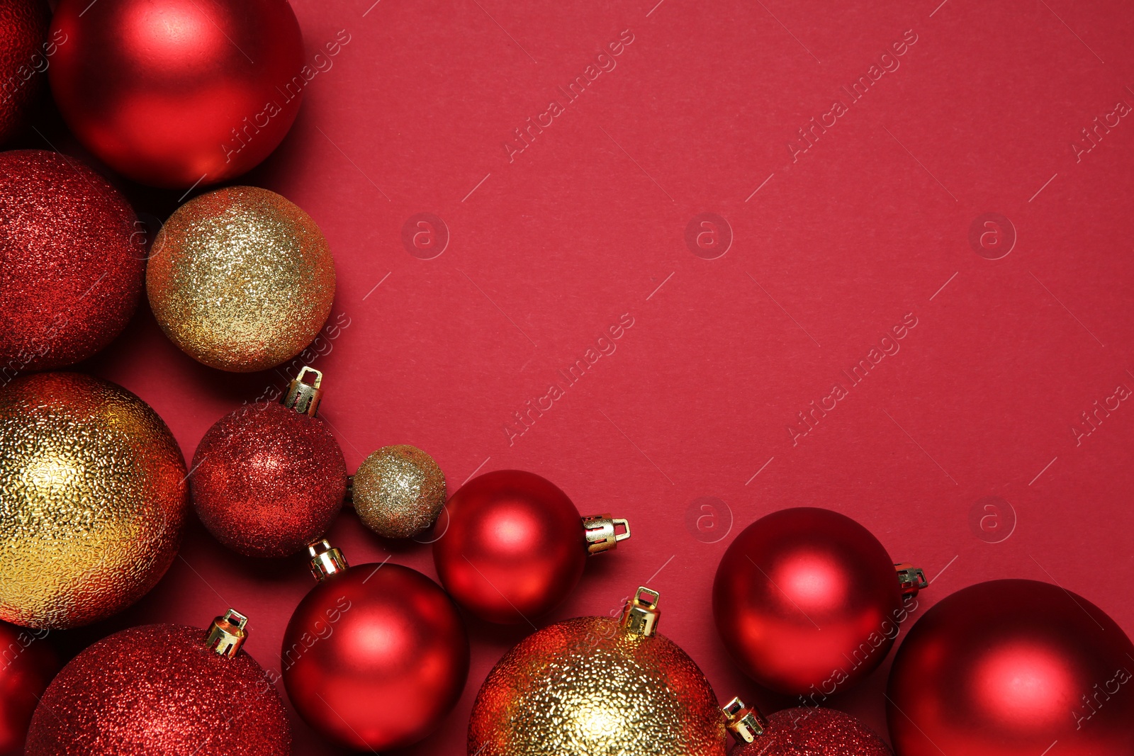 Photo of Christmas balls on red background, top view. Space for text