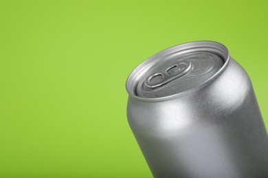 Can of energy drink on green background, closeup. Space for text