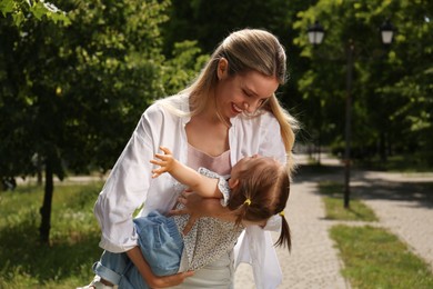 Happy mother with her daughter having fun in park