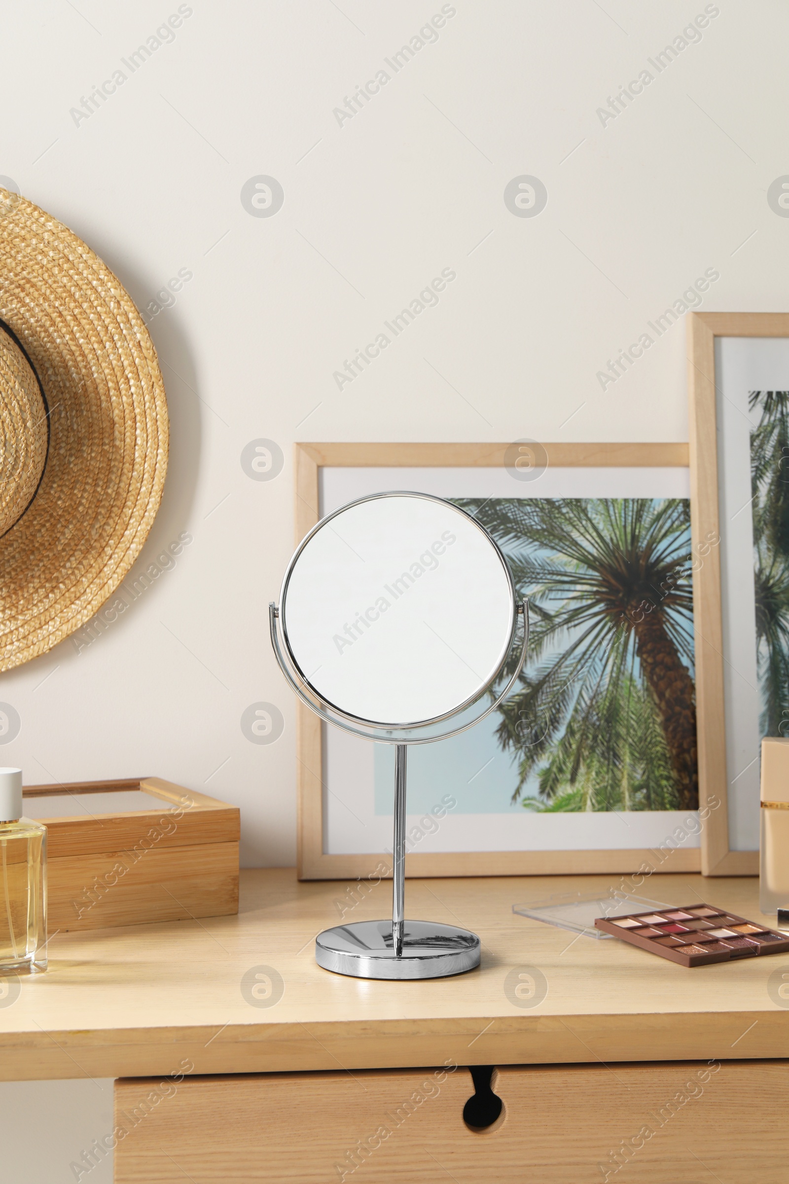 Photo of Mirror, perfume and accessories on wooden makeup table