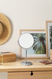 Mirror, perfume and accessories on wooden makeup table