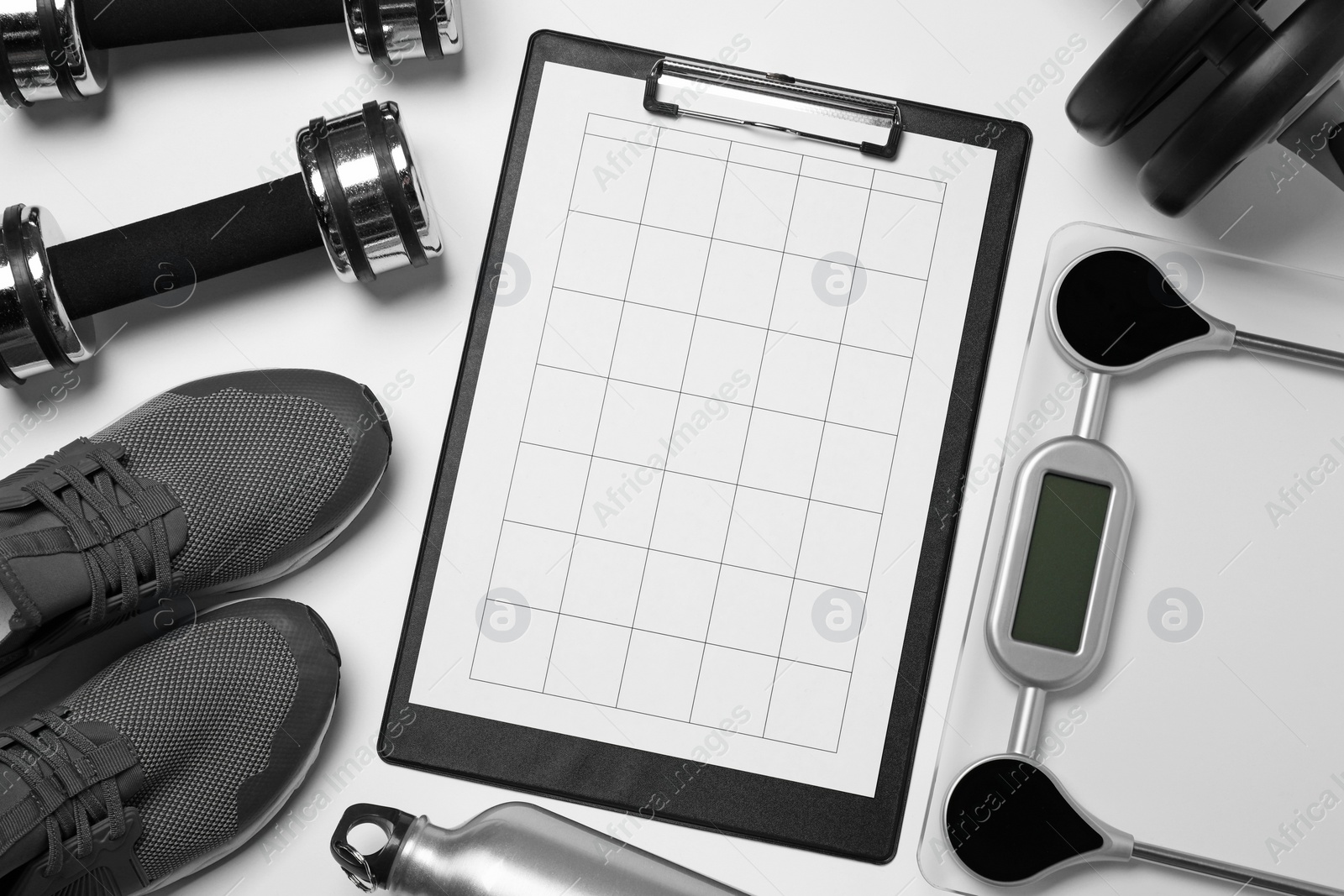 Photo of Clipboard with workout plan and sports equipment on white background, flat lay. Personal training