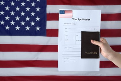 Photo of Woman holding visa application form and passport against American flag, closeup. Space for text