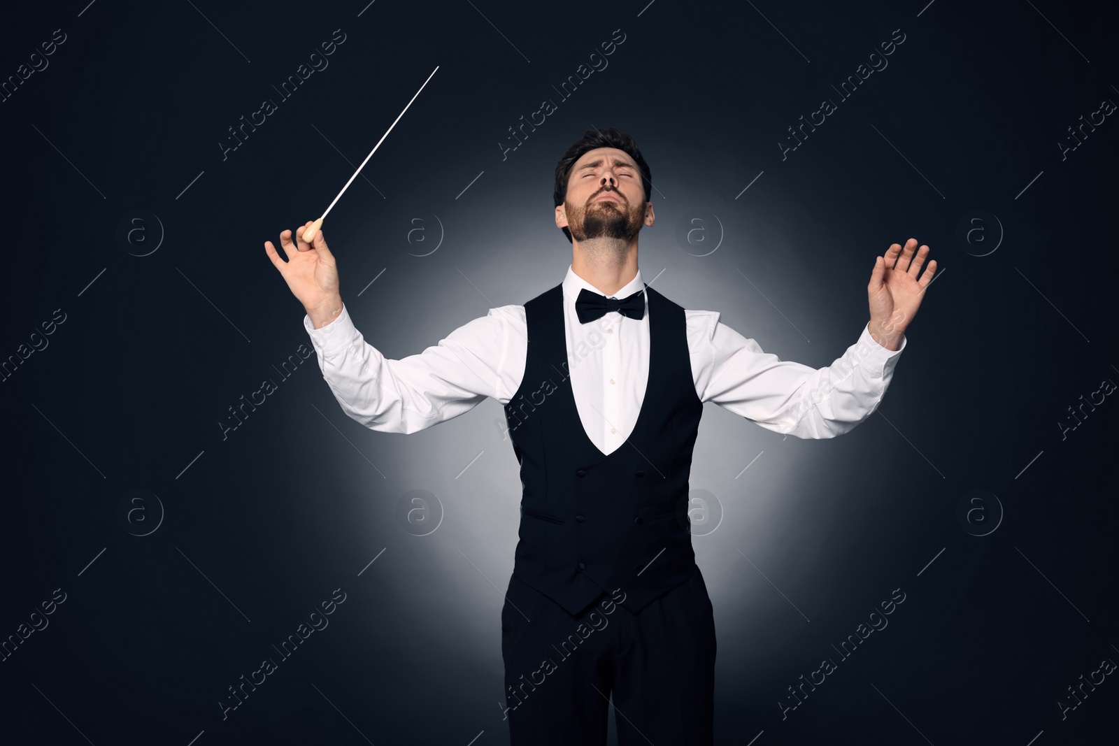Photo of Professional conductor with baton on dark background