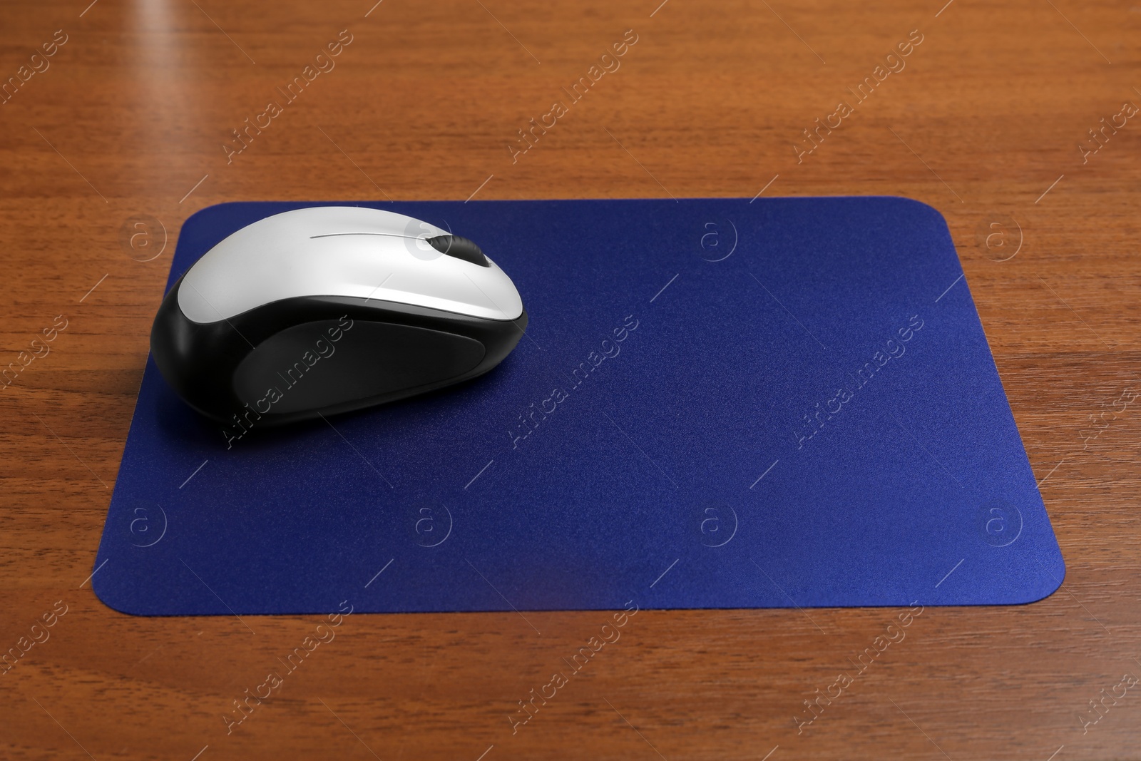Photo of Blank pad and wireless computer mouse on wooden background