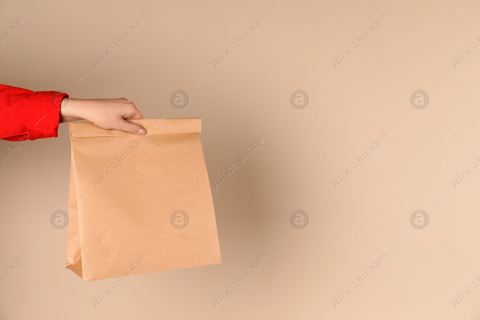 Photo of Woman holding paper bag on color background. Mockup for design