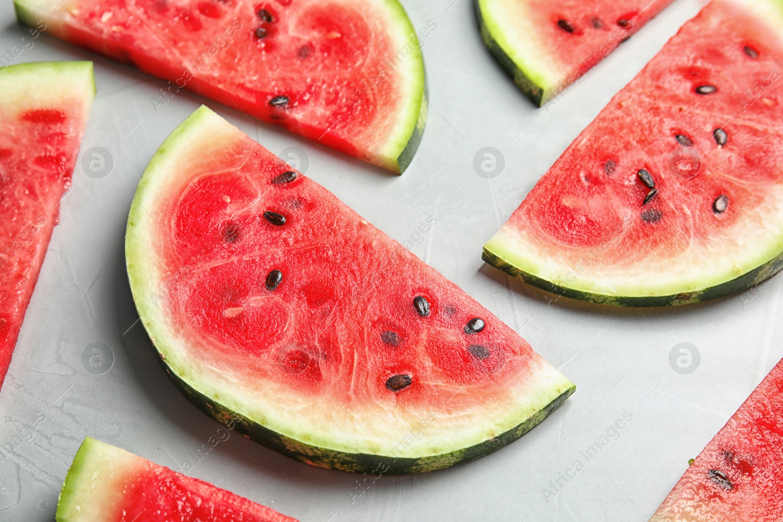 Photo of Fresh juicy watermelon slices on grey background