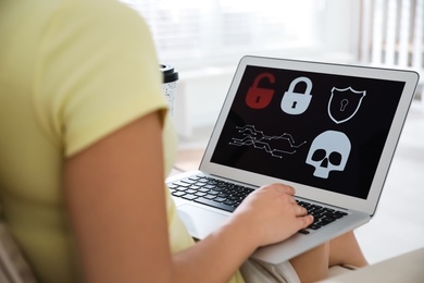 Photo of Woman holding laptop with virus illustration on screen at home, closeup