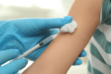 Doctor vaccinating little child in clinic, closeup