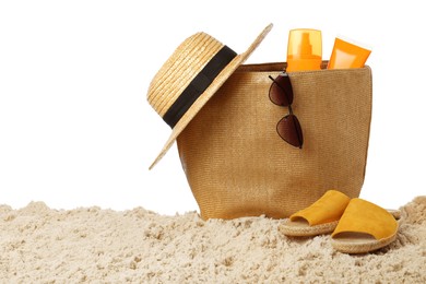 Stylish bag with beach accessories on sand against white background