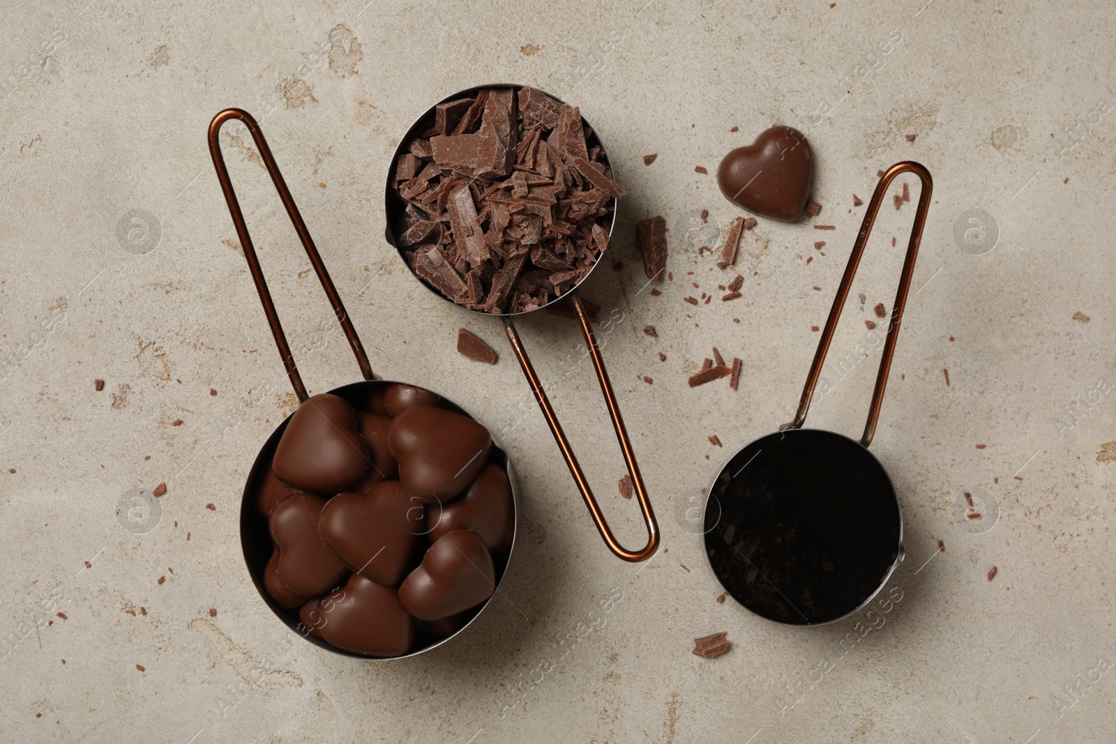 Photo of Flat lay composition with delicious heart shaped chocolate candies on light table