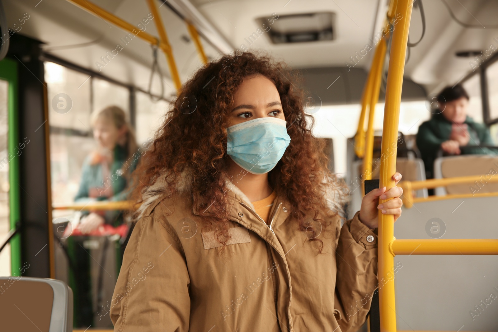 Photo of African-American woman with disposable mask on bus. Virus protection