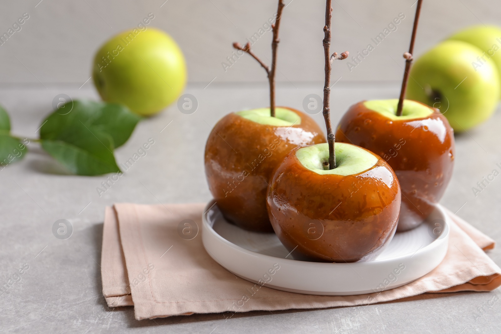 Photo of Plate with delicious green caramel apples on table