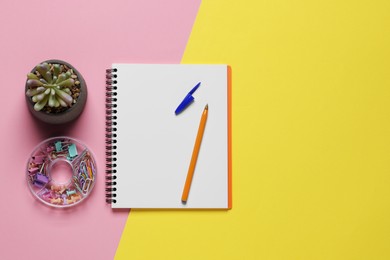 Photo of Ballpoint pen, notebook and different clips on color background, flat lay