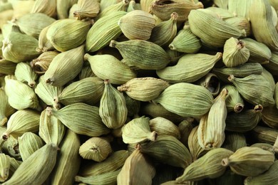 Dry green cardamom pods as background, closeup