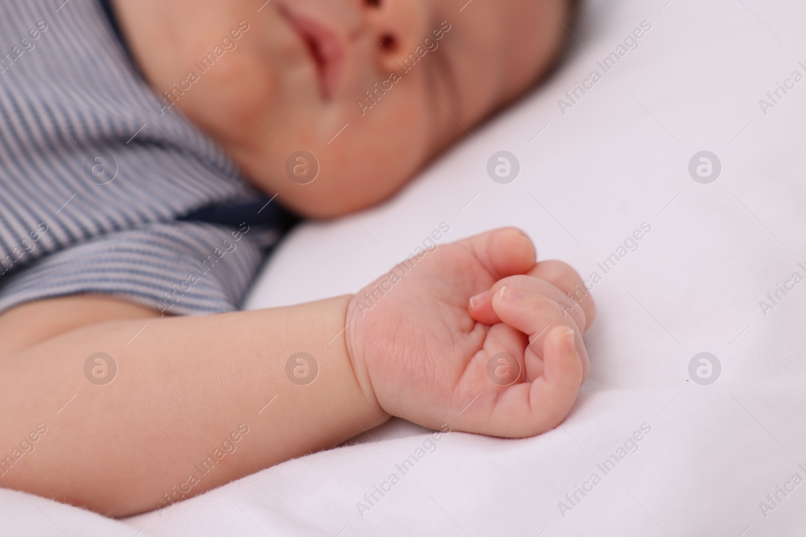Photo of Cute newborn baby sleeping on white blanket, closeup