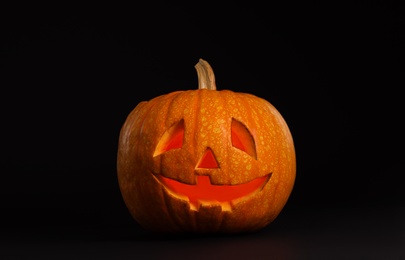 Photo of Pumpkin head on black background. Jack lantern - traditional Halloween decor