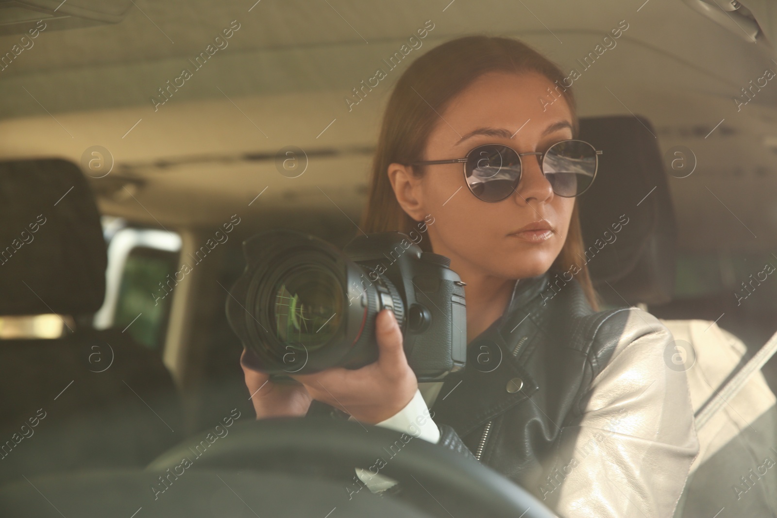 Photo of Private detective with camera spying from car