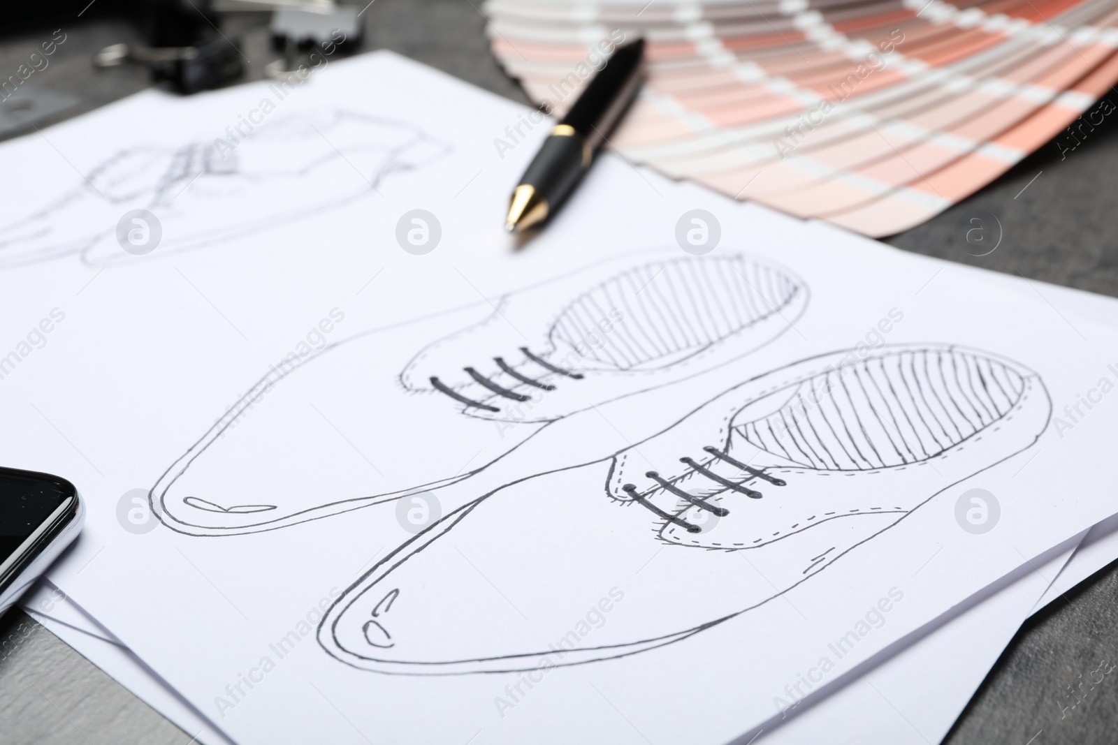 Photo of Drawing of shoes on table, closeup. Designer's workplace