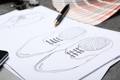 Photo of Drawing of shoes on table, closeup. Designer's workplace