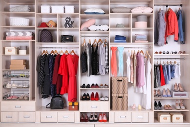 Photo of Large wardrobe with different clothes, home stuff and shoes