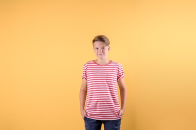 Teenage boy in casual clothes on color background