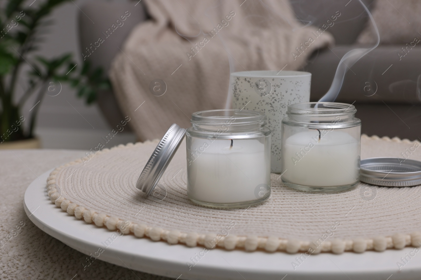 Photo of Blown out candles in jars on white table indoors