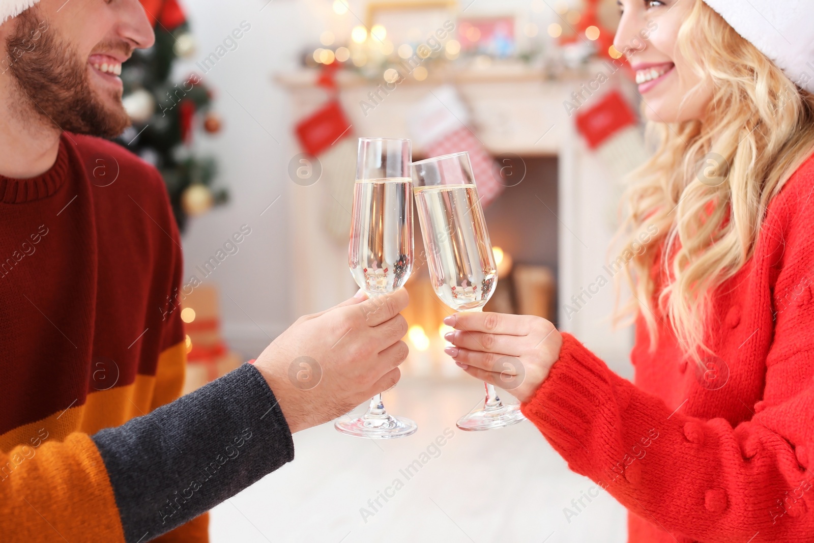 Photo of Young couple with glasses of champagne at home. Christmas celebration