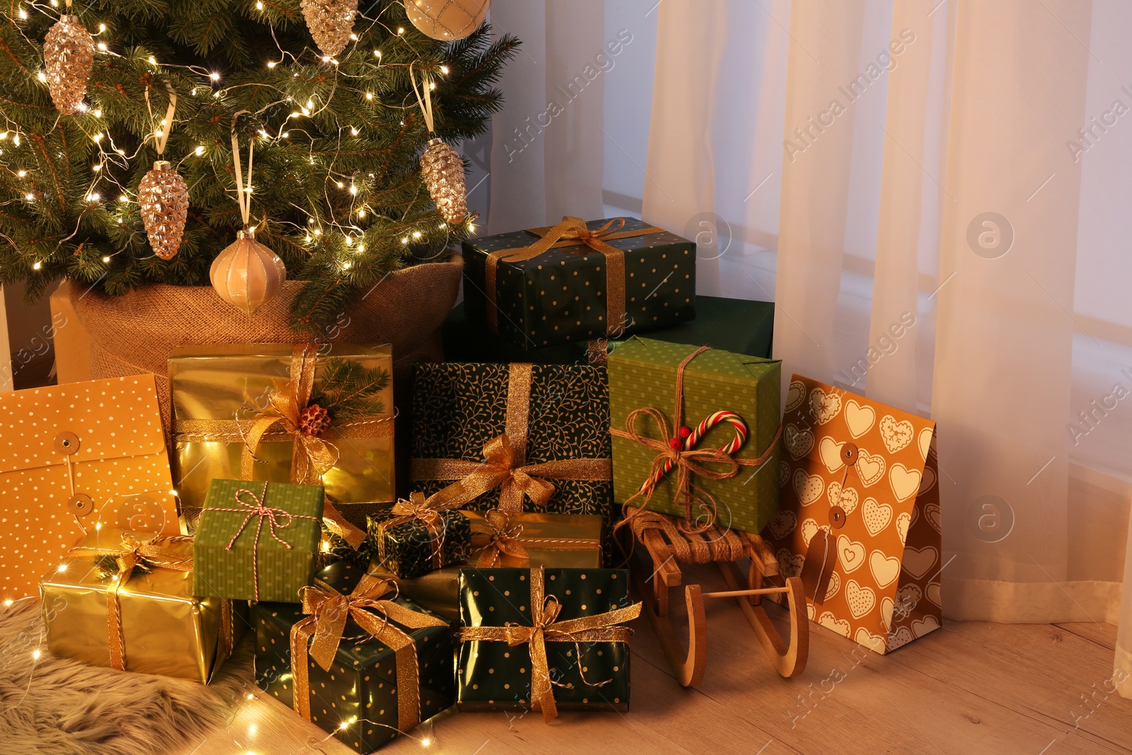 Photo of Many different gifts under Christmas tree indoors