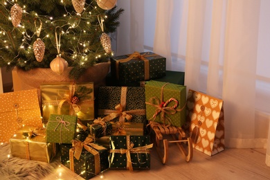 Photo of Many different gifts under Christmas tree indoors