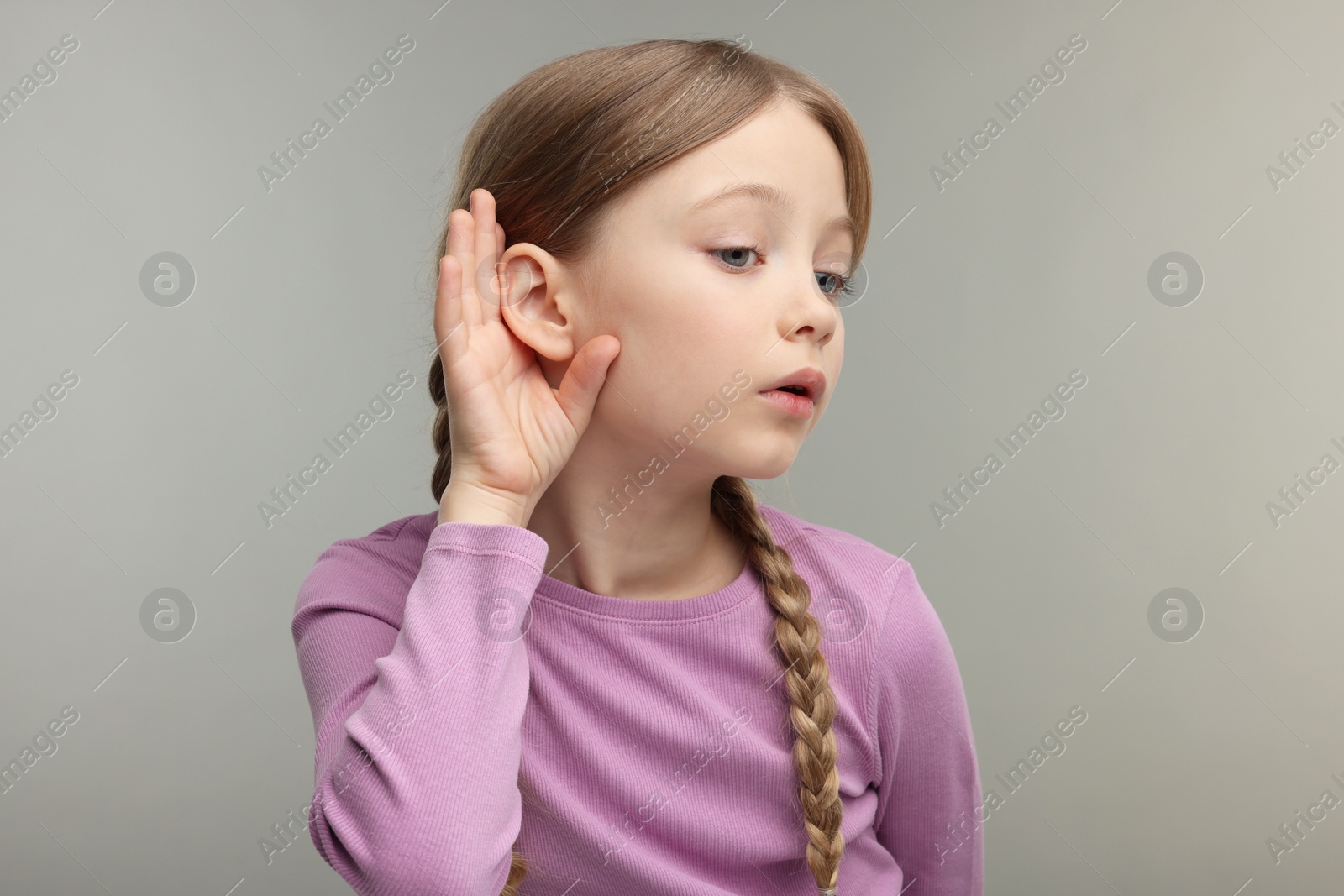 Photo of Little girl with hearing problem on grey background