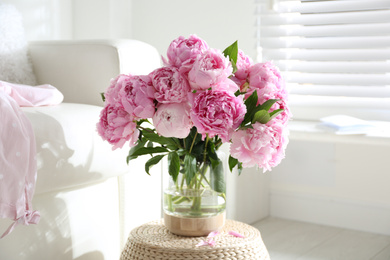 Photo of Bouquet of beautiful peonies on pouf indoors