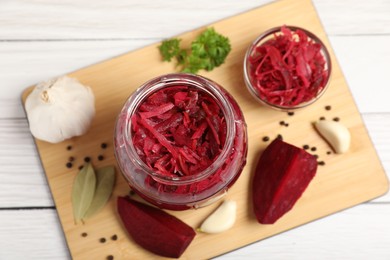 Jar with delicious pickled beetroot and spices on white table, top view