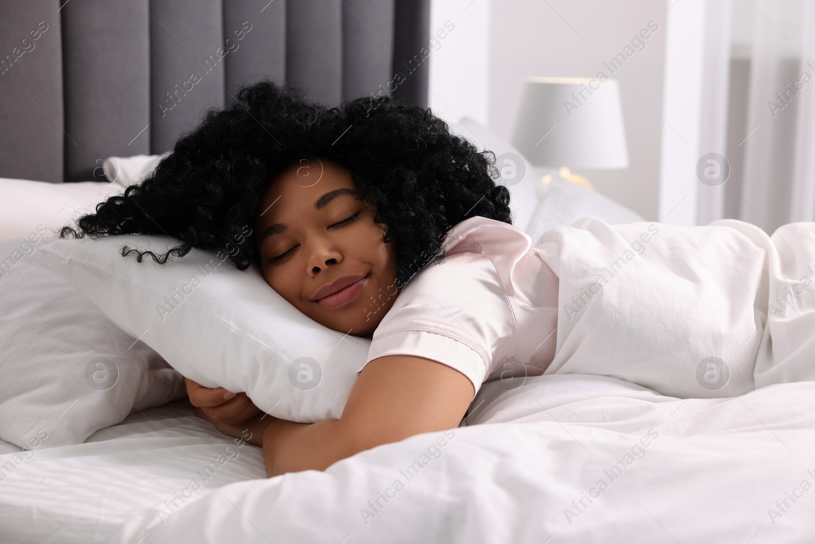 Photo of Beautiful young woman sleeping in soft bed at home