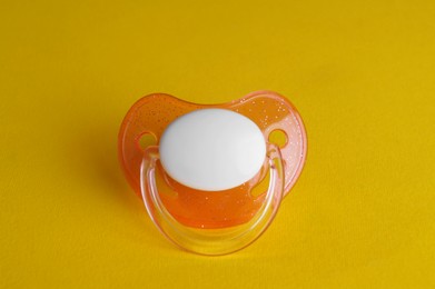 Photo of New cute baby pacifier on yellow background