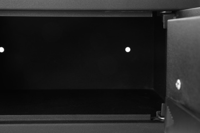Photo of Modern open empty black steel safe, closeup