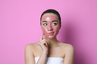 Woman with pomegranate face mask on pink background