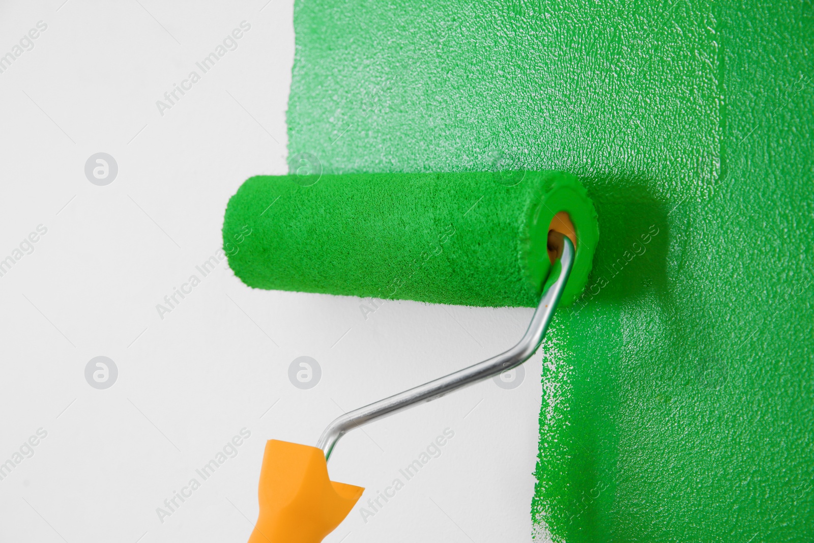 Photo of Painting white wall with green dye, closeup. Interior renovation