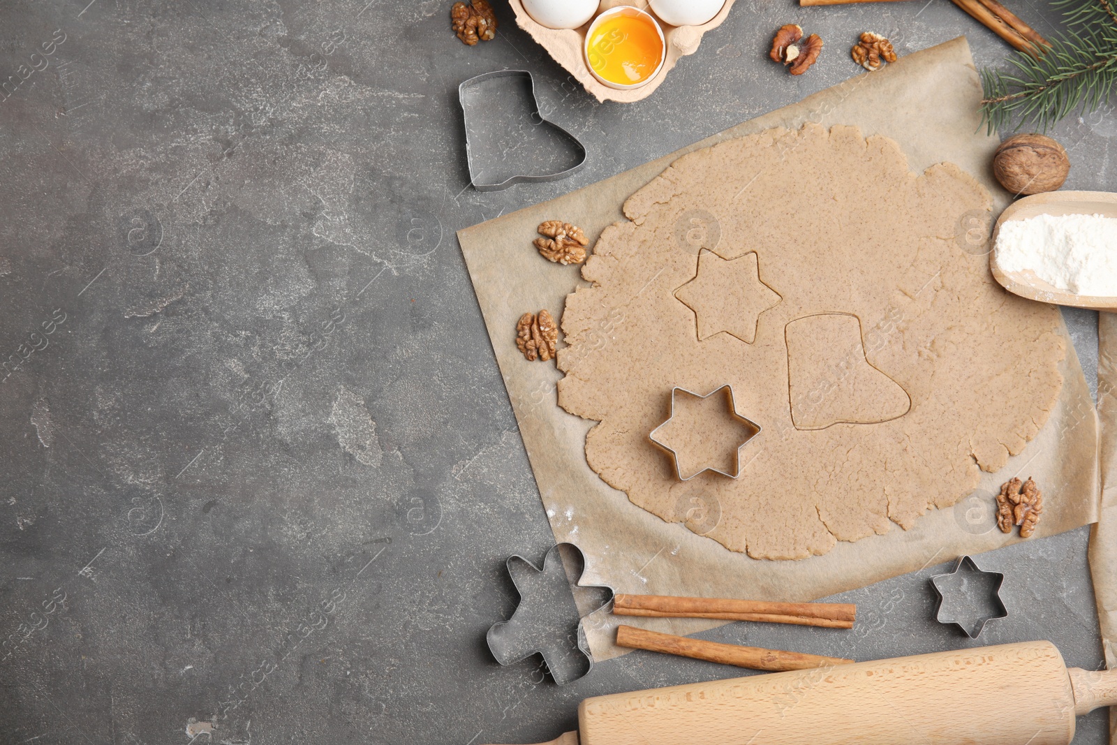 Photo of Homemade Christmas cookies. Flat lay composition with dough on grey table, space for text