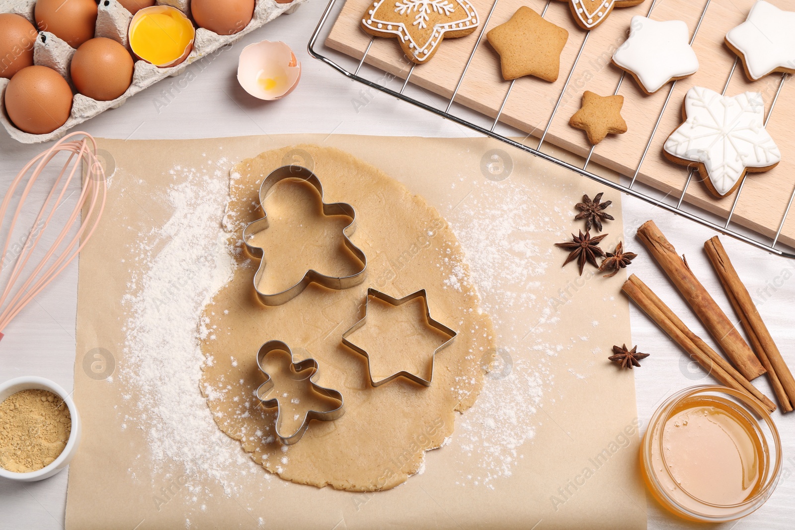 Photo of Making Christmas cookies. Flat lay composition with ingredients and raw dough on white wooden table