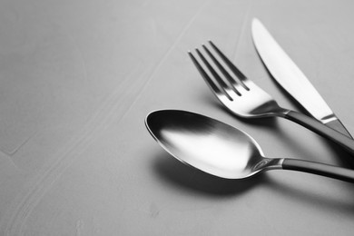 Photo of Set of cutlery on grey table, closeup. Space for text