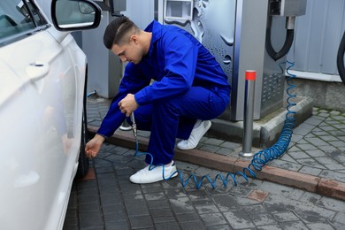 Professional mechanic inflating tire at car service