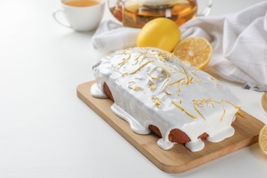 Photo of Tasty lemon cake with glaze on white table. Space for text