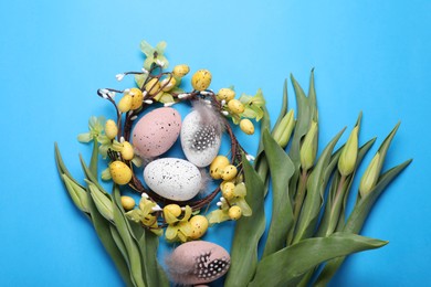 Photo of Flat lay composition with flowers and eggs on light blue background. Easter celebration