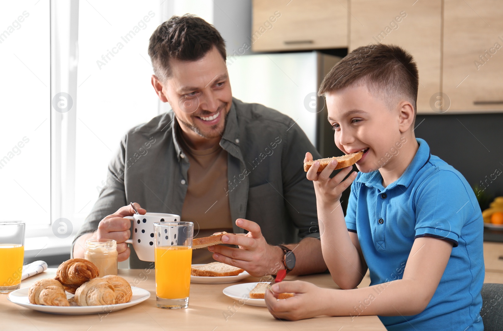 Photo of Dad and son having breakfast together in kitchen