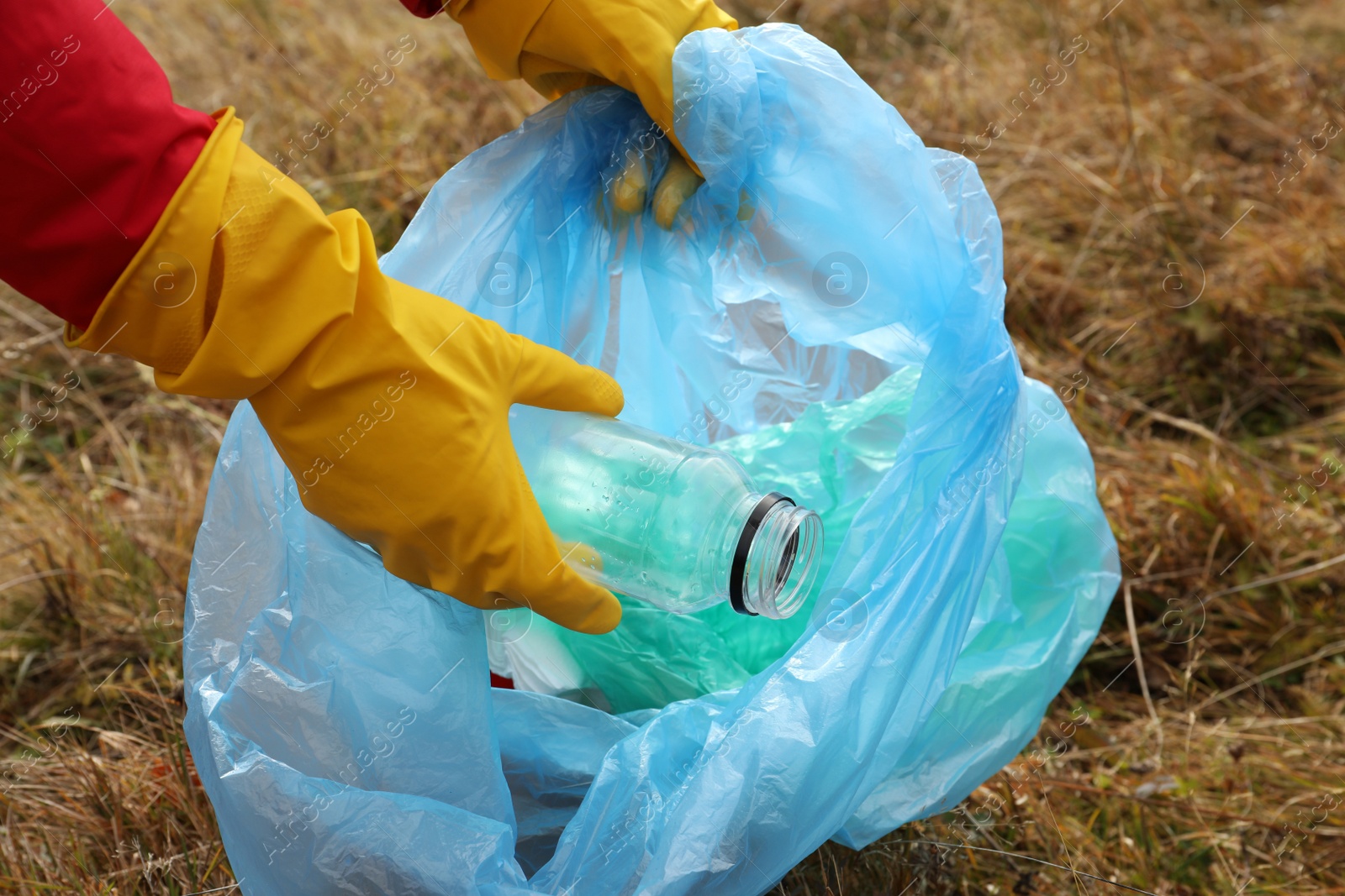 Photo of Woman with trash bag collecting garbage in nature, closeup