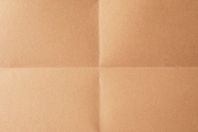 Photo of Folded kraft paper sheet as background, top view