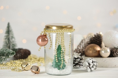Photo of Handmade snow globe and Christmas decorations on white table