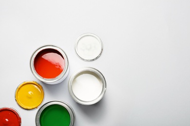 Photo of Open paint cans and space for text on grey background, top view